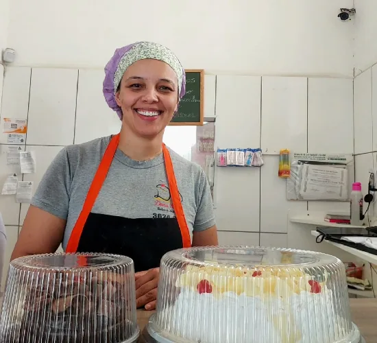 Atendente com bolos prontos para retirada